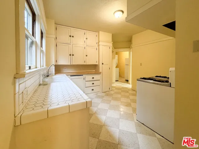 a bathroom with a granite countertop sink and a tub