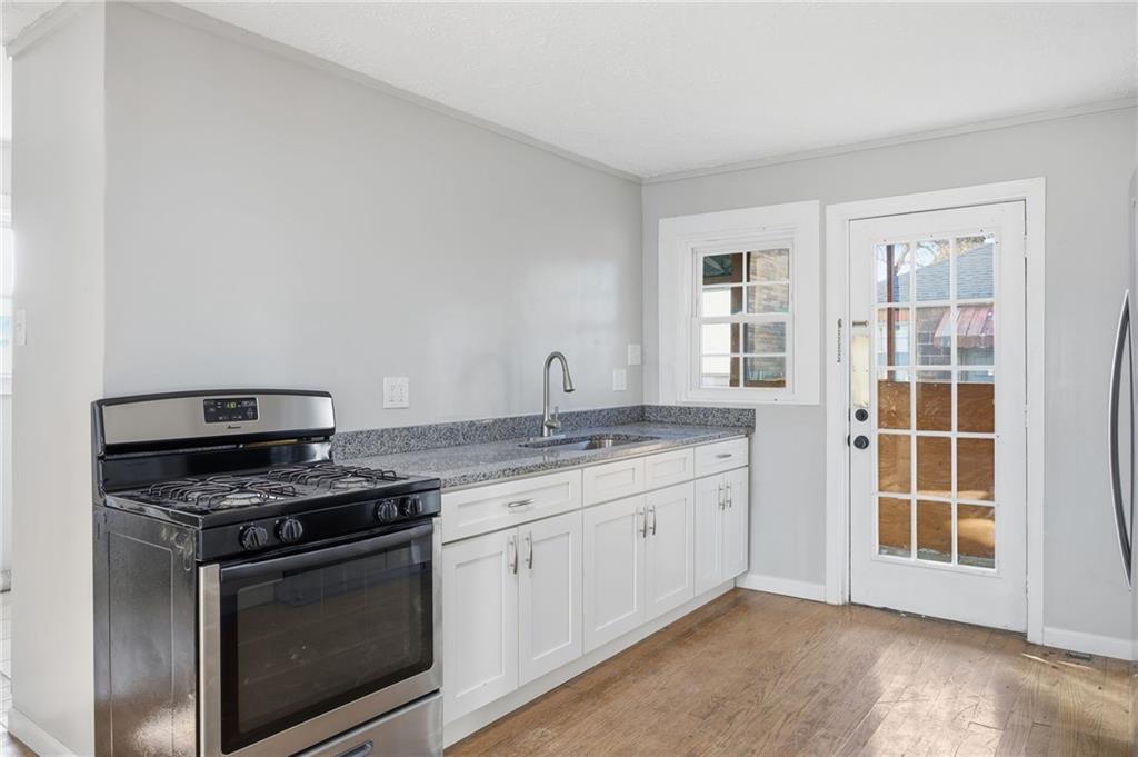 212 Comrie Avenue Braddock, PA 15104 - Photo 4 of 18 a kitchen with granite countertop a stove and a sink