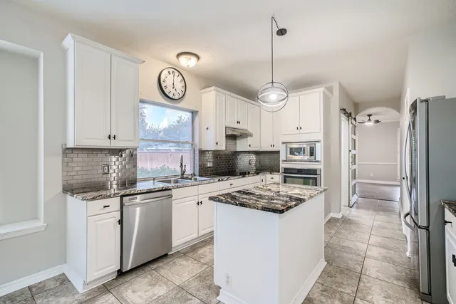 a kitchen with refrigerator cabinets and stainless steel appliances