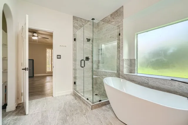 a bathroom with a tub shower and sink