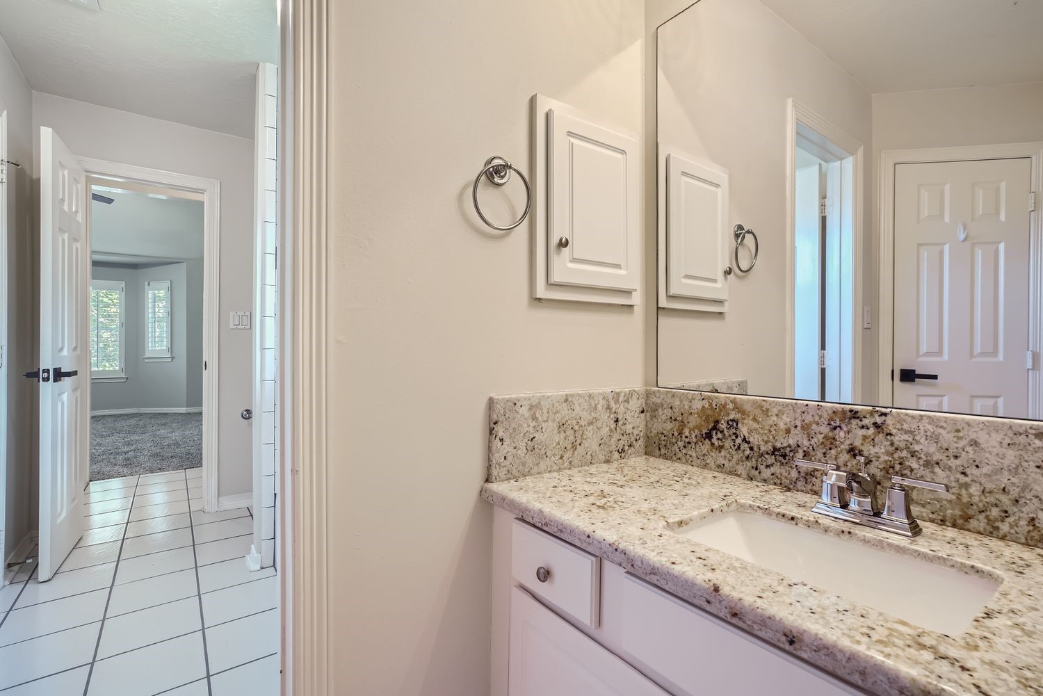 17 Leandro Court Montgomery, TX 77356 - Photo 31 of 38 a bathroom with a granite countertop sink and a mirror