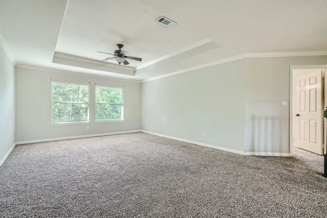an empty room with a window and a ceiling fan