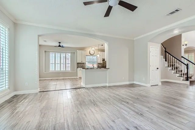 an empty room with wooden floor and windows