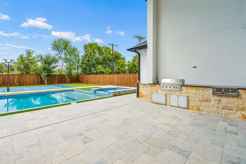 6606 Curtis Road Colleyville, TX 76034 - Photo 32 of 39 Expansive patio with stone-clad outdoor kitchen featuring a built-in grill and sink