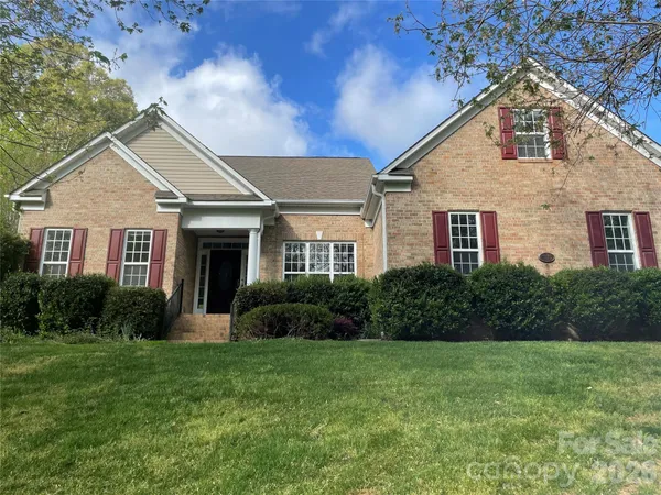 a front view of a house with a yard and green space