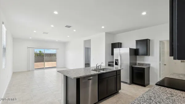 a kitchen with stainless steel appliances granite countertop a refrigerator and a sink
