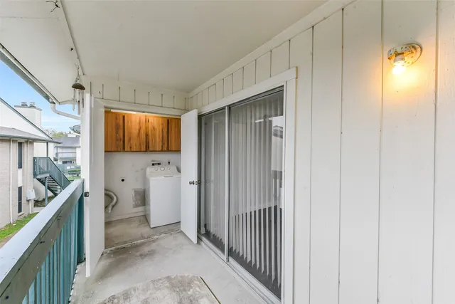 a view of a hallway with bathroom and wooden floor