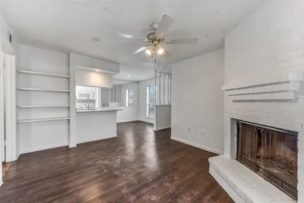 a view of an empty room with a fireplace and window