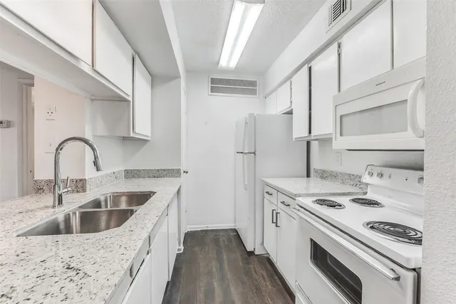 a kitchen that has a sink a stove and refrigerator