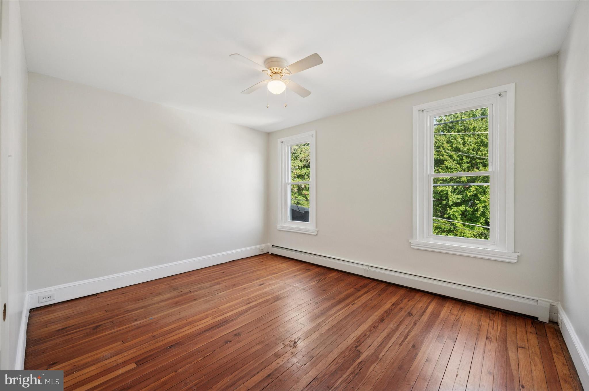 610 Martin Street Philadelphia, PA 19128 - Photo 18 of 24 an empty room with wooden floor chandelier fan and windows
