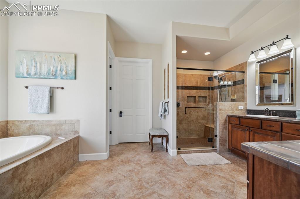 1724 Valley Stream Court Colorado Springs, CO 80921 - Photo 17 of 49 a spacious bathroom with a granite countertop sink mirror and bathtub