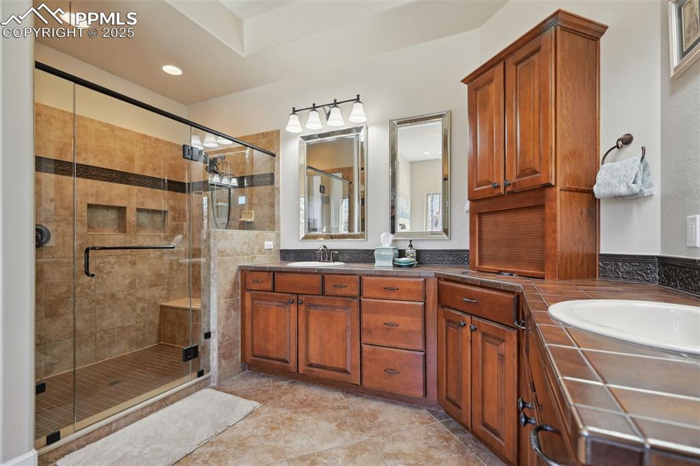 1724 Valley Stream Court Colorado Springs, CO 80921 - Photo 19 of 49 a bathroom with a granite countertop sink mirror and double