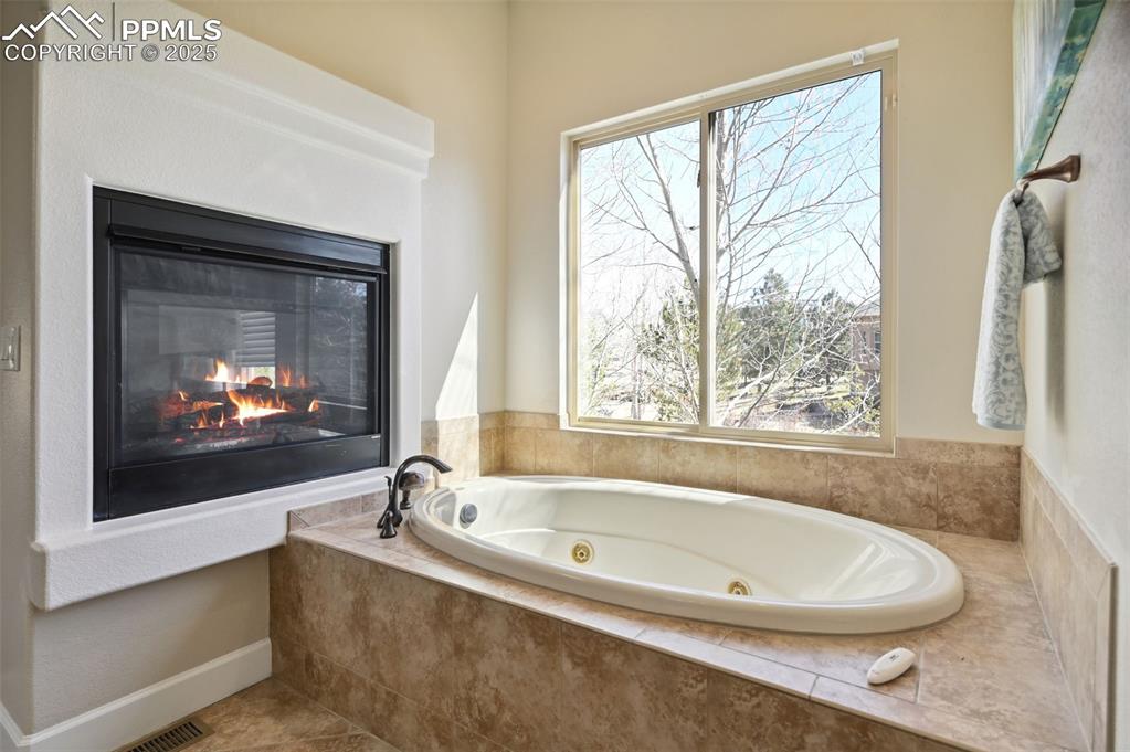 1724 Valley Stream Court Colorado Springs, CO 80921 - Photo 21 of 49 a white bath tub sitting in a bathroom next to a window