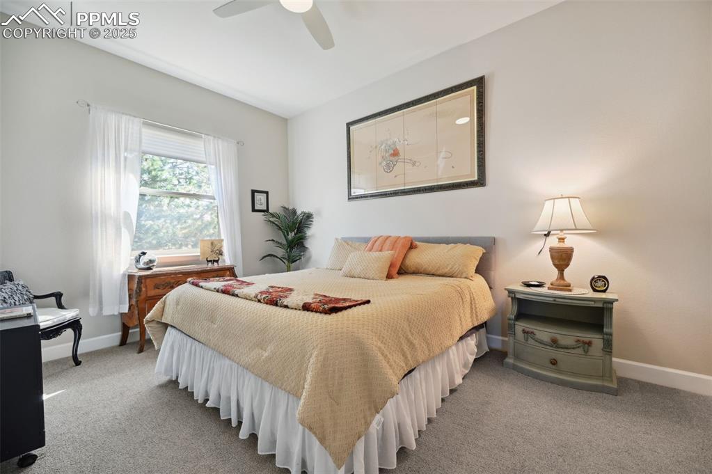 1724 Valley Stream Court Colorado Springs, CO 80921 - Photo 22 of 49 a bedroom with bed a lamp and a window