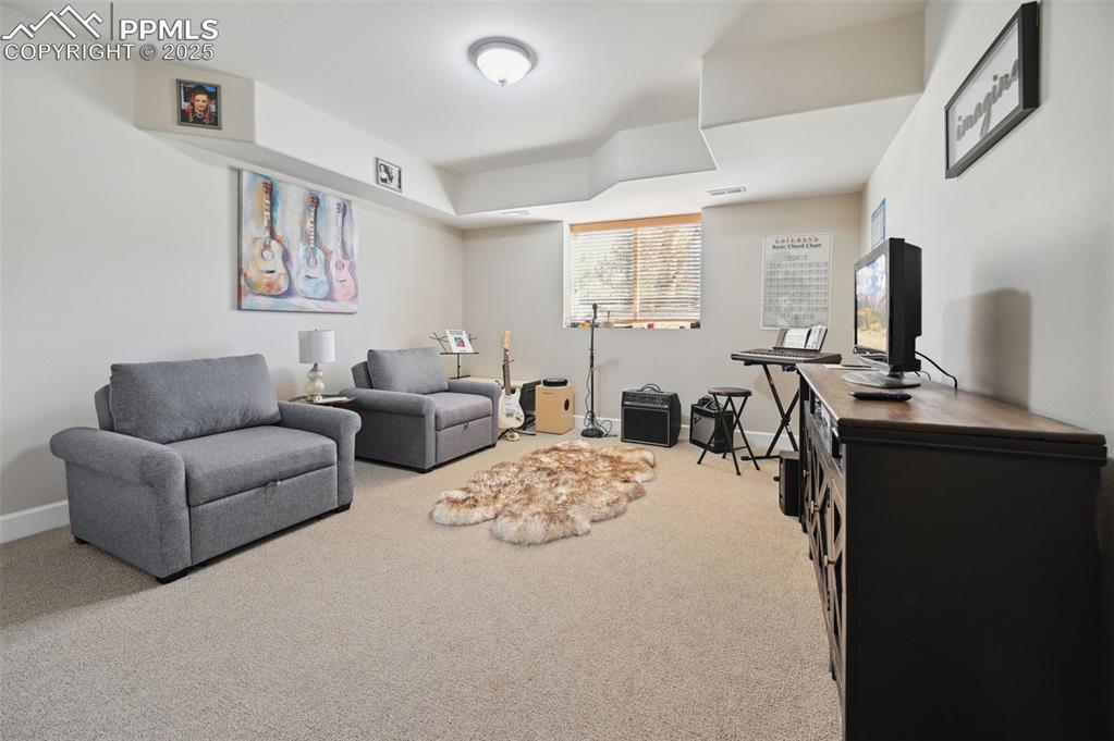 1724 Valley Stream Court Colorado Springs, CO 80921 - Photo 39 of 49 a living room with furniture a large window and a flat screen tv