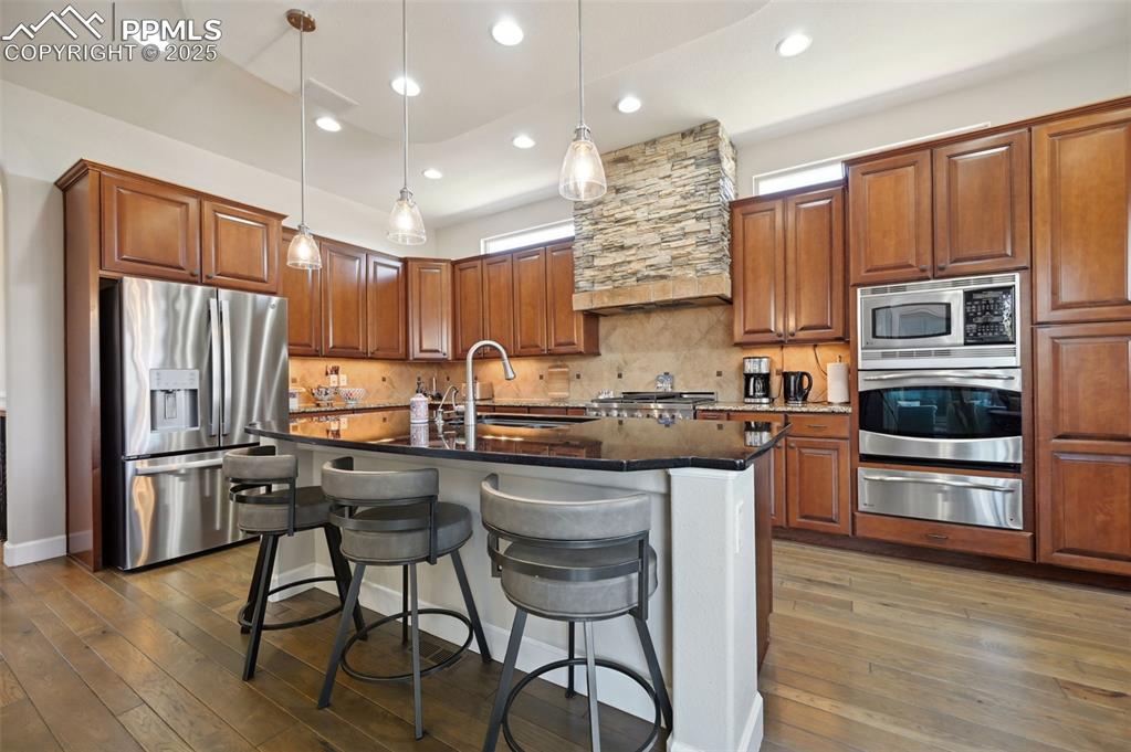 1724 Valley Stream Court Colorado Springs, CO 80921 - Photo 9 of 49 a kitchen with kitchen island granite countertop wooden cabinets and stainless steel appliances