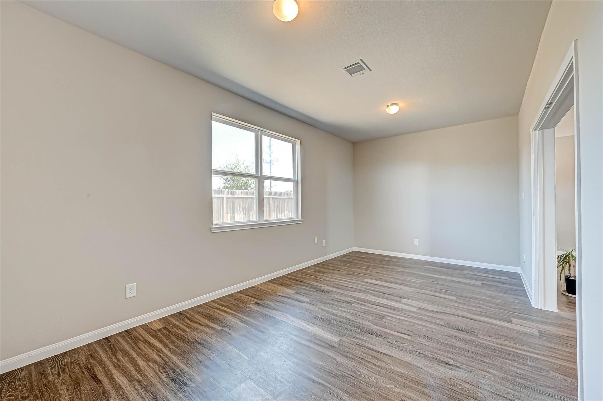 18606 Lansdowne Stream Path Katy, TX 77449 - Photo 11 of 39 an empty room with wooden floor and windows