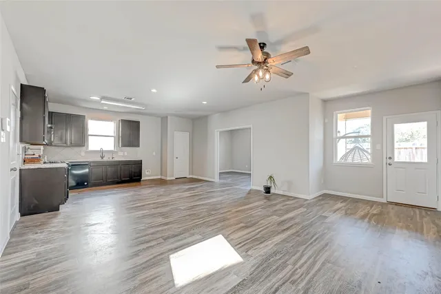 a view of an empty room with window and wooden floor