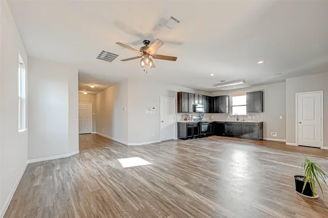 a view of a kitchen with furniture wooden floor and a ceiling fan