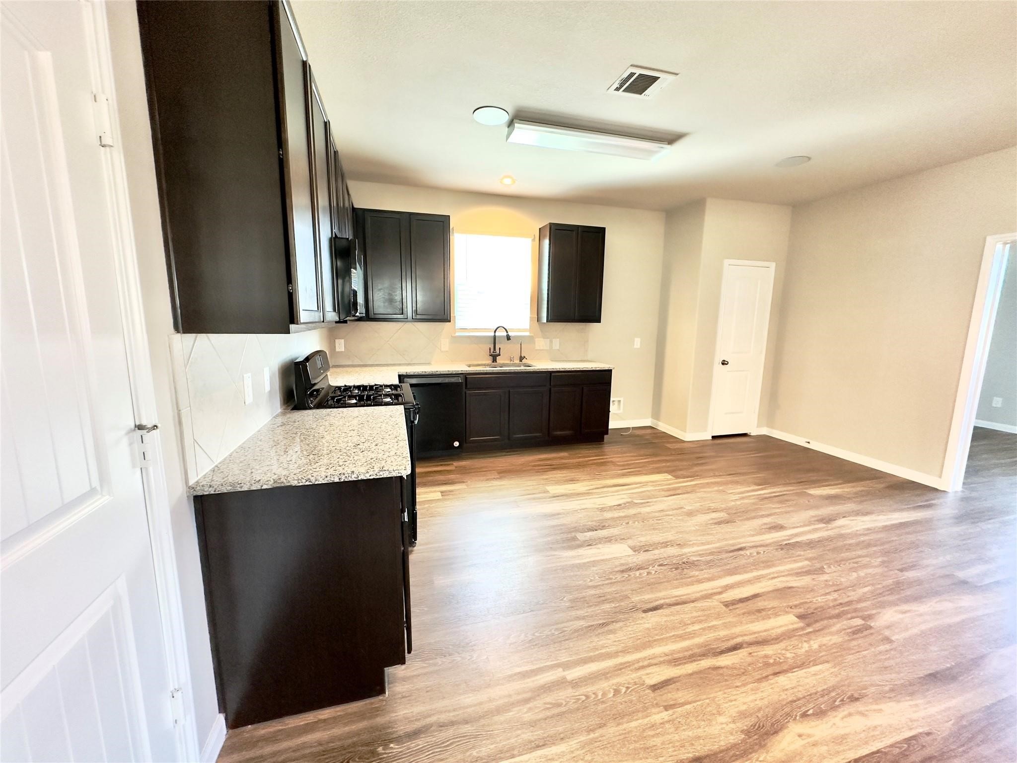 18606 Lansdowne Stream Path Katy, TX 77449 - Photo 17 of 39 a view of kitchen with kitchen island a sink wooden floor and living room