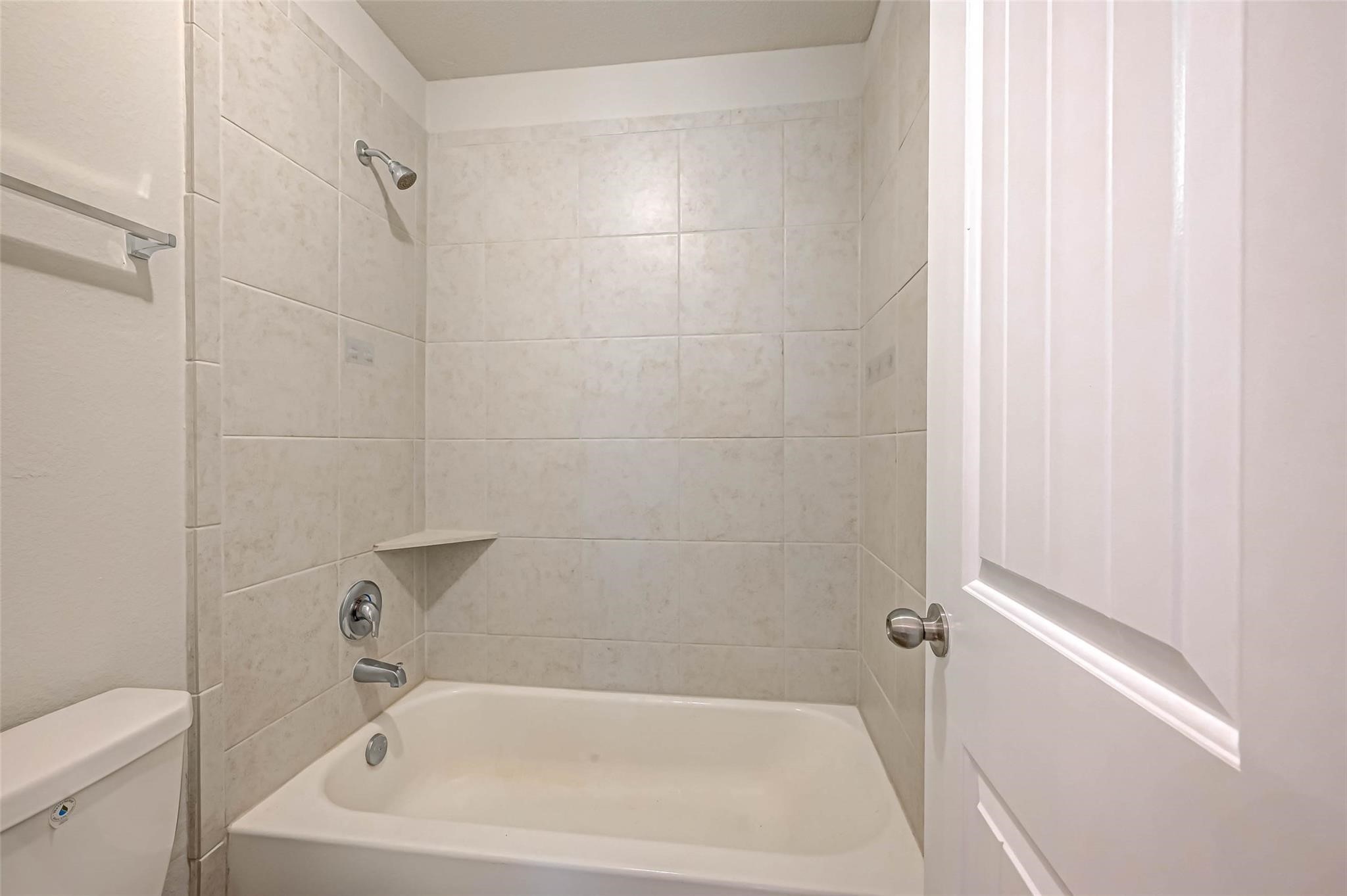 18606 Lansdowne Stream Path Katy, TX 77449 - Photo 22 of 39 a white bath tub sitting next to a white toilet and sink
