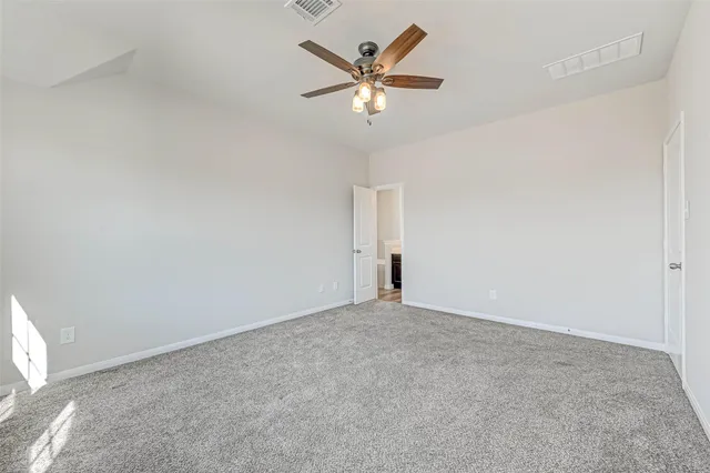 an empty room with closet and fan