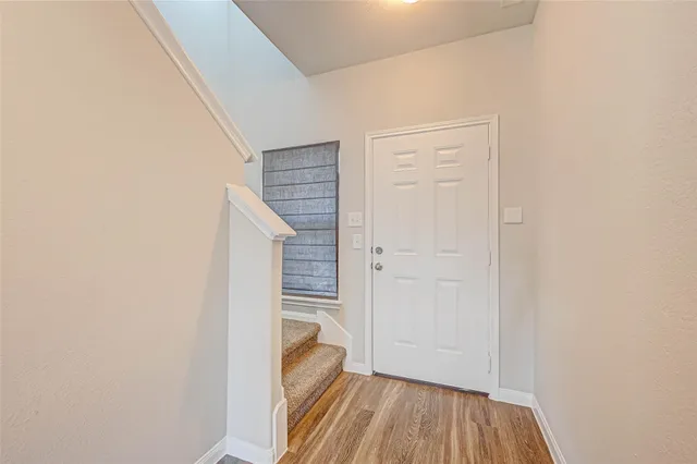 a view of a hallway with wooden floor and entryway