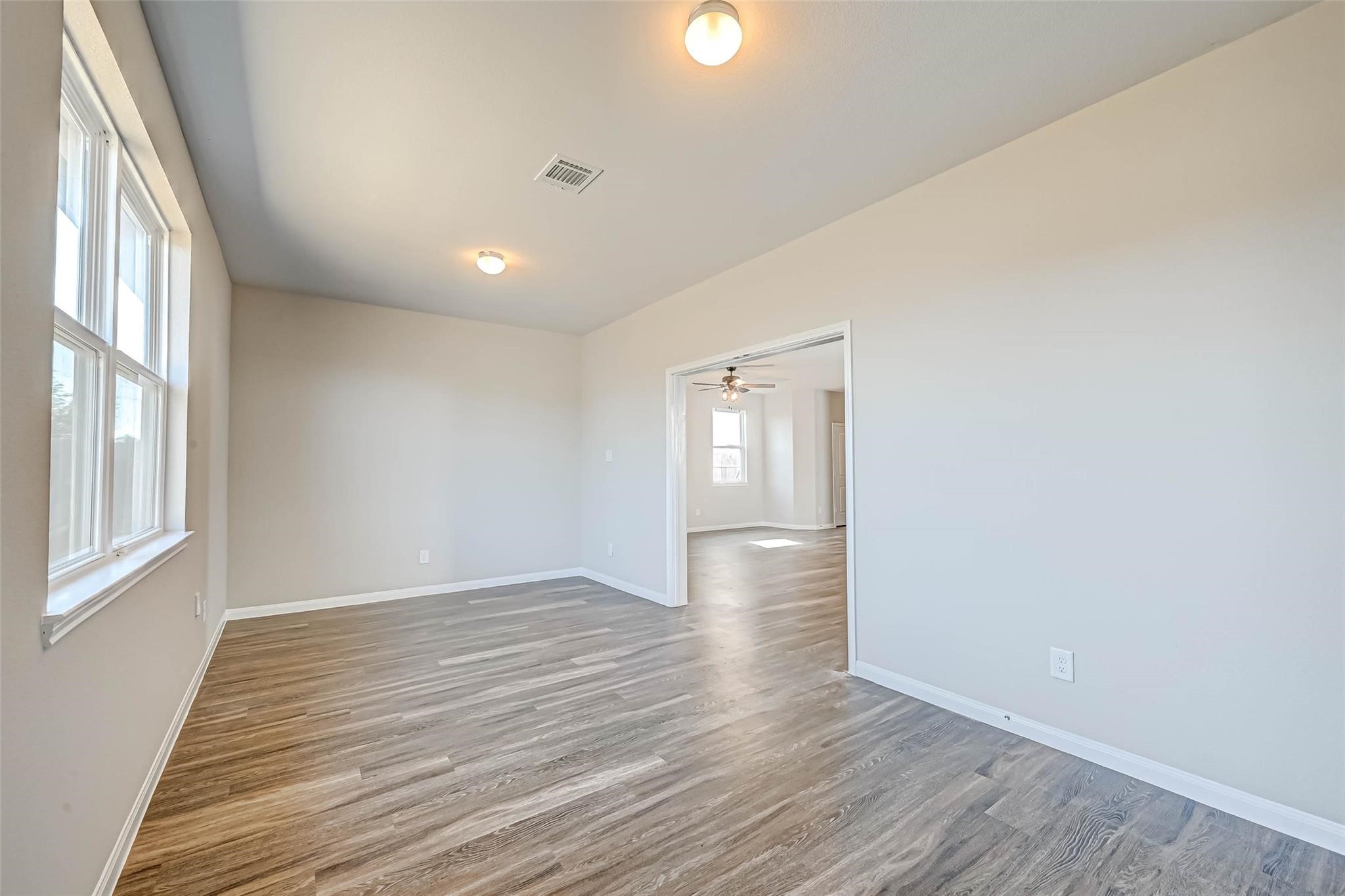 18606 Lansdowne Stream Path Katy, TX 77449 - Photo 10 of 39 a view of an empty room with wooden floor and a window