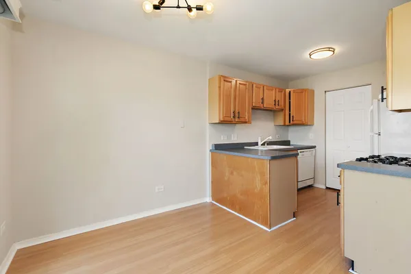 a kitchen with granite countertop a stove a sink and a refrigerator