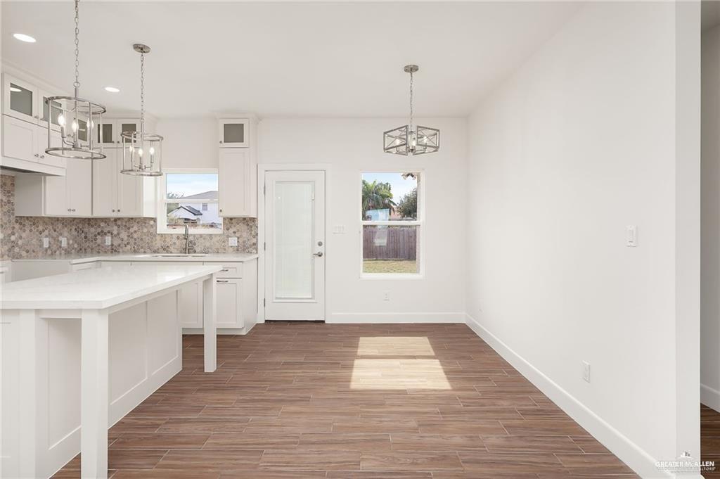 2110 Trinity Street Donna, TX 78537 - Photo 6 of 17 a kitchen with kitchen island granite countertop a sink cabinets and wooden floor