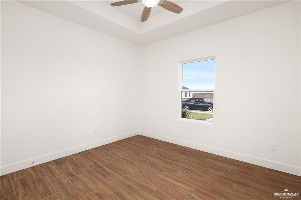 2110 Trinity Street Donna, TX 78537 - Photo 8 of 17 an empty room with a window and a ceiling fan