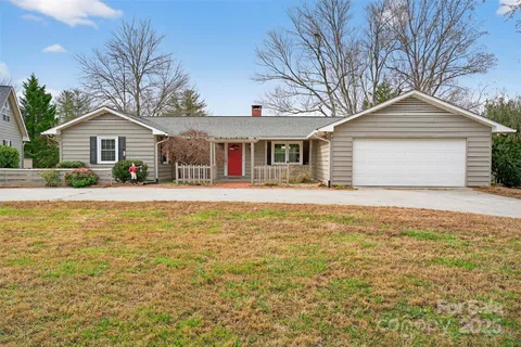 a front view of house with yard and trees around