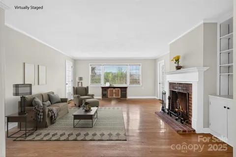 a living room with furniture large window and a fireplace