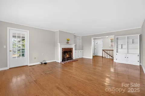 a view of empty room with wooden floor and fireplace