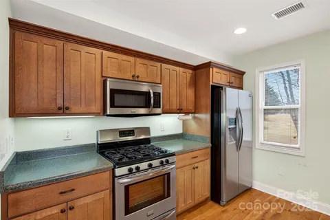 a kitchen with stainless steel appliances granite countertop a refrigerator stove and microwave