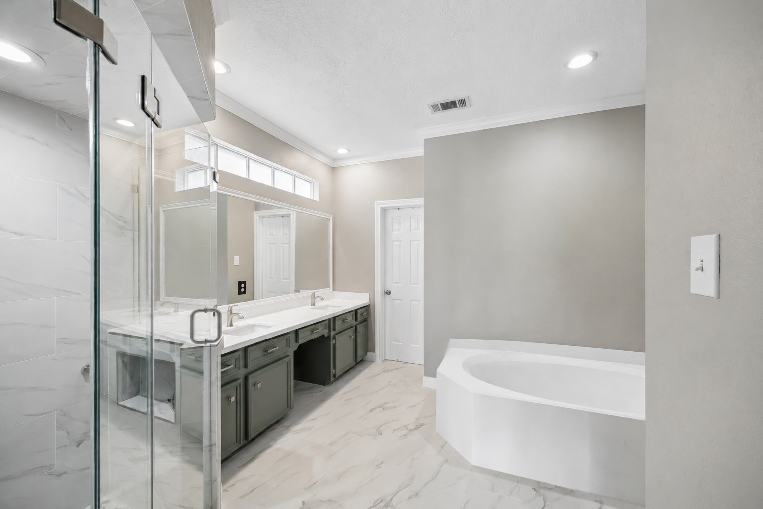 7915 Huddersfield Court Spring, TX 77379 - Photo 21 of 37 Fully updated primary bath with dual sinks, modern cabinetry, soaking tub, separate glass-enclosed shower, and polished finishes throughout.