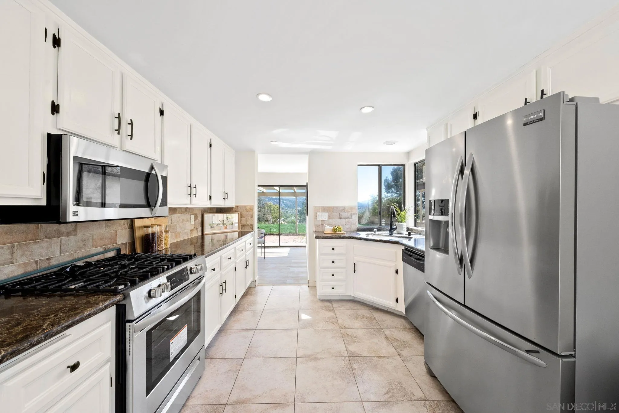 1436 Timber Escondido, CA 92027 - Photo 14 of 44 a large kitchen with stainless steel appliances granite countertop a refrigerator sink and white cabinets