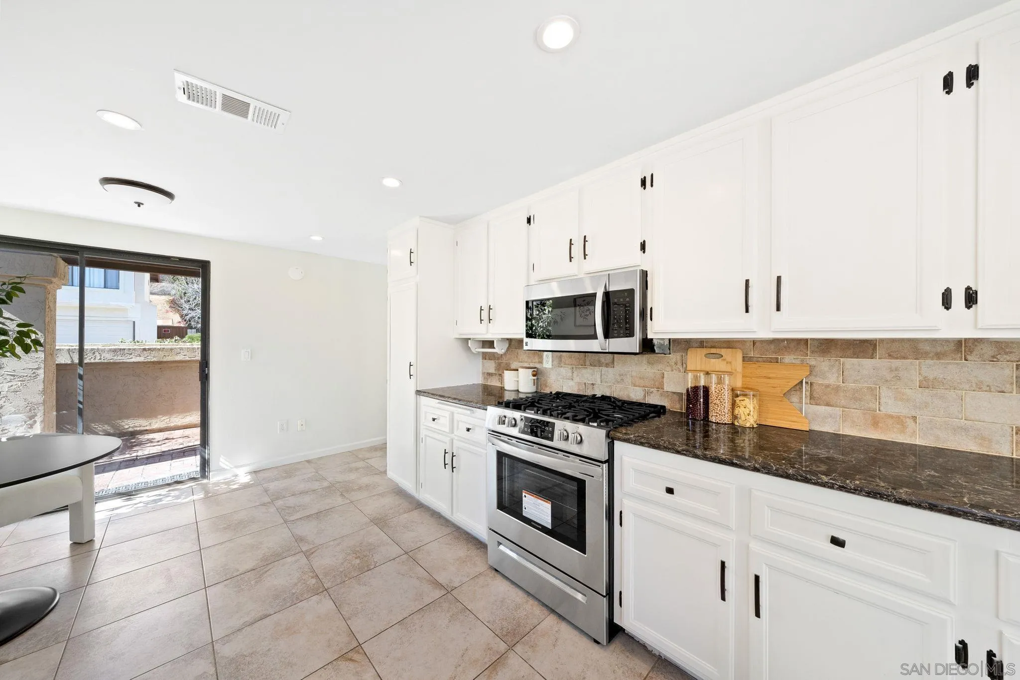 1436 Timber Escondido, CA 92027 - Photo 18 of 44 a kitchen with stainless steel appliances granite countertop a stove a sink and white cabinets