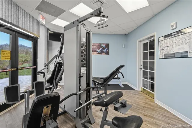 a dining room with wooden floor a chandelier a wooden table and chairs