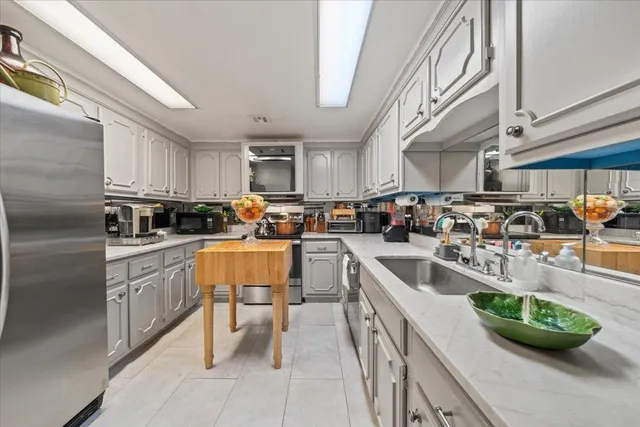 a kitchen with counter top space a sink stainless steel appliances and cabinets