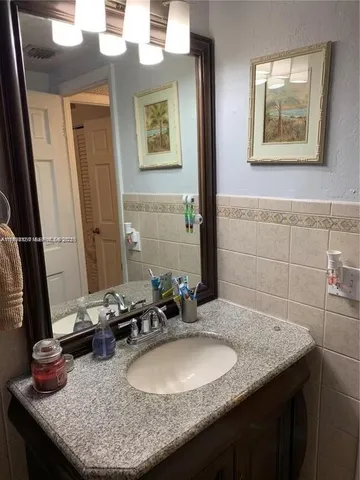 a bathroom with a granite countertop sink and a mirror