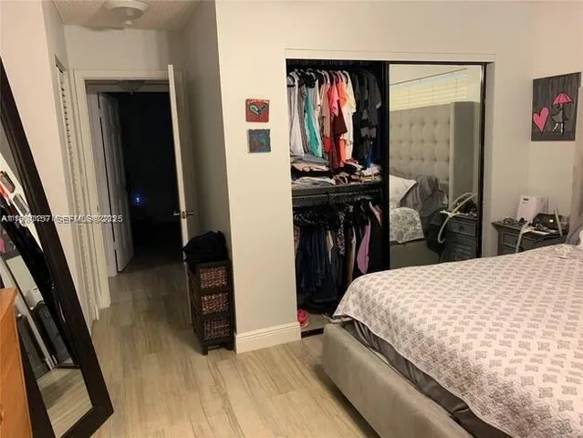 a bedroom with a bed and a view of living room