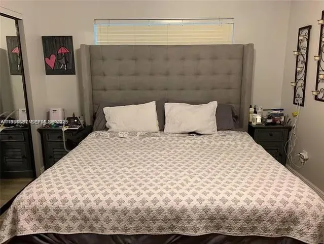 a bedroom with a bed and a night stand