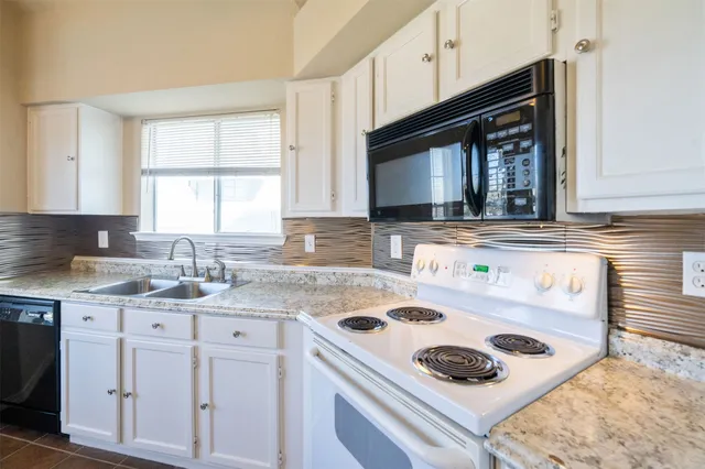a kitchen with kitchen island a sink a stove and cabinets