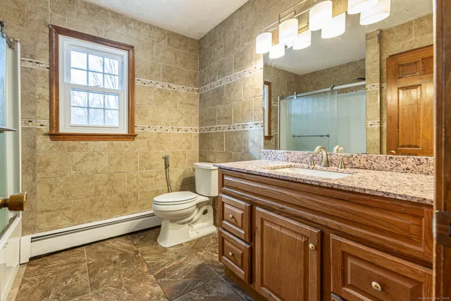 a bathroom with a granite countertop sink and a mirror