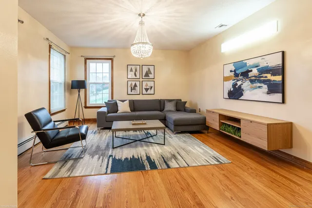 a living room with furniture and a wooden floor