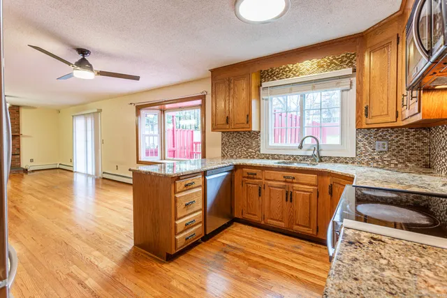 a kitchen with stainless steel appliances granite countertop a sink stove and wooden cabinets