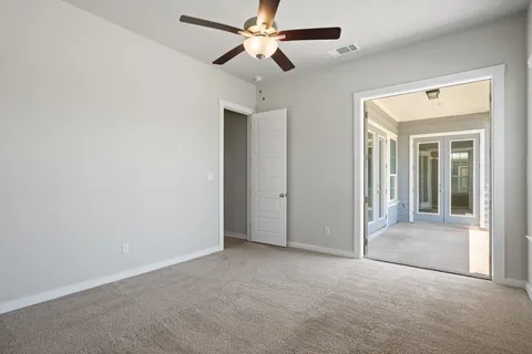 en empty room with ceiling fan and window