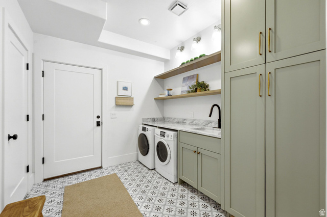 3027 Homestead Road Park City, UT 84098 - Photo 19 of 62 Laundry room featuring patterned floor tiles, light green cabinetry with gold-tone hardware, a sink with a matte black faucet, open wood shelving, and white doors with matte black hardware