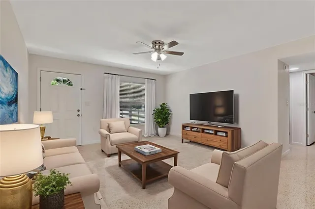 a living room with furniture a flat screen tv and a window